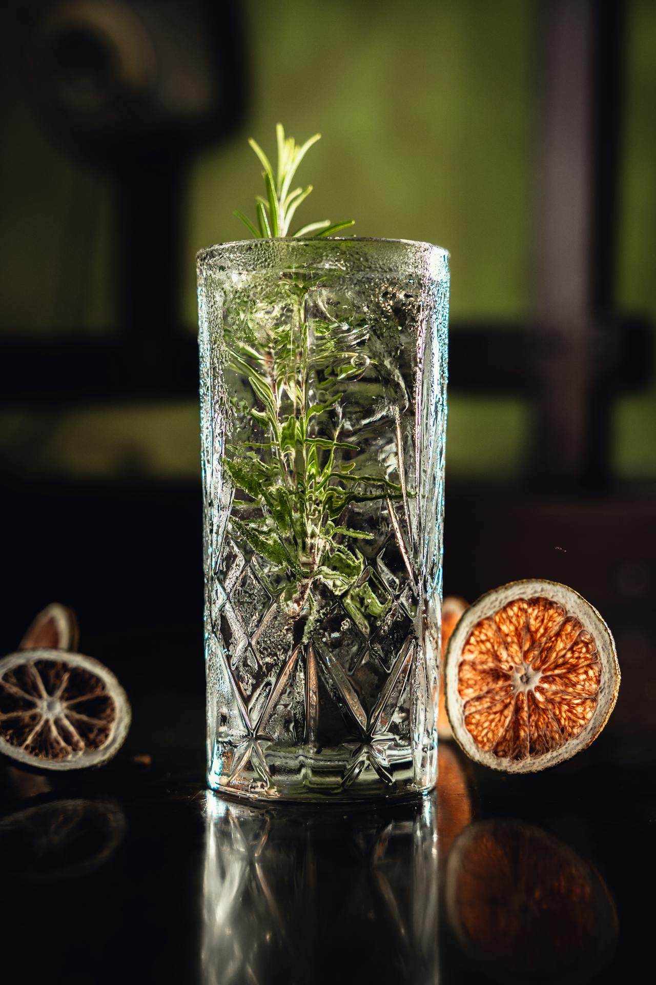 Serviere den L³ Gin in einem Glas mit Rosmarin und Blutorange.